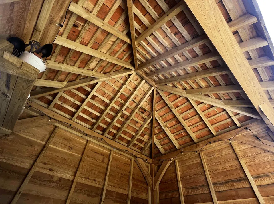Exposed oak posts, braces and roof framing inside a timber garden building